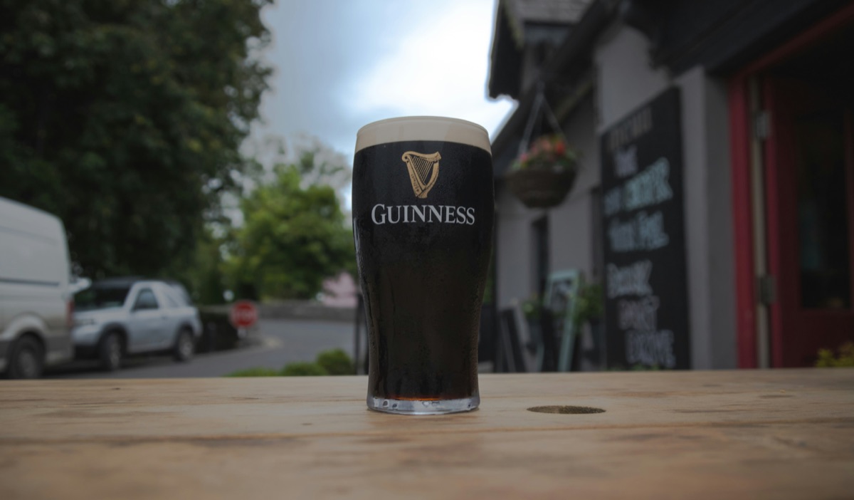A pint of Guinness settling on a table outside an Irish pub